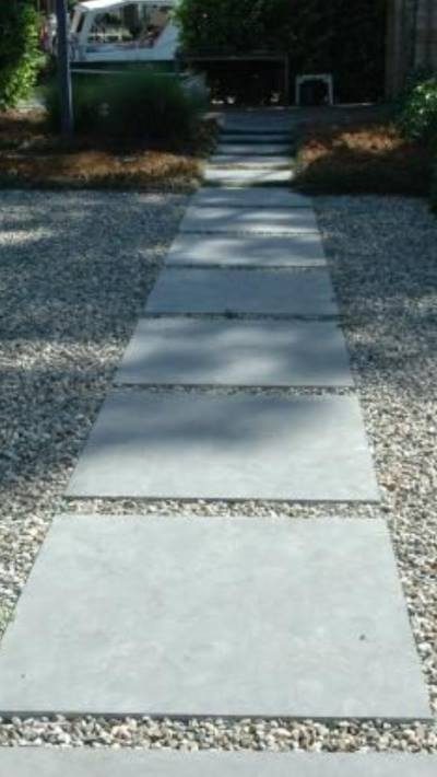 Tuinpad aangelegd met kiezels langs beplanting